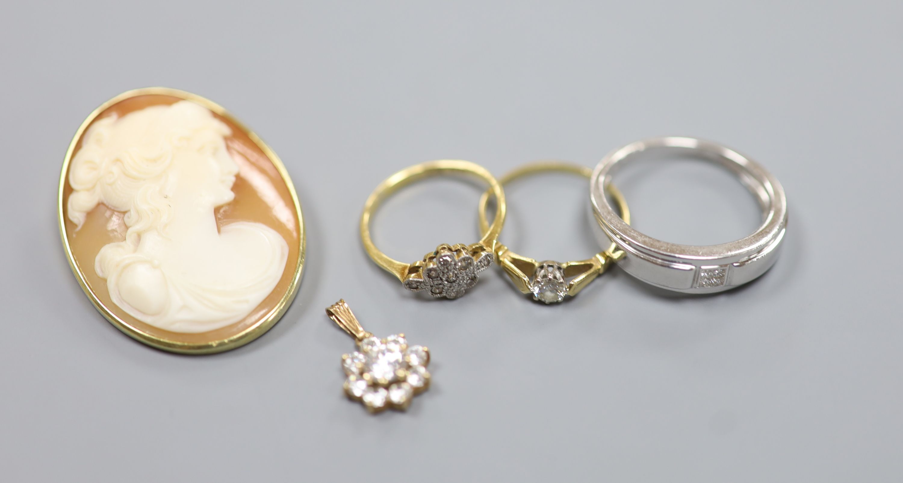 A modern 9ct white gold and diamond ring and a 9ct pendant, gross 4.7 grams, two 18ct and diamond rings, gross 3.6 grams and a yellow metal mounted cameo shell brooch, gross 9.5 grams.